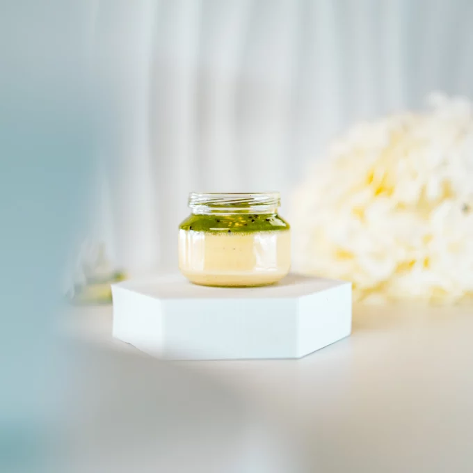 Deser panna cotta w słoiczku z musem kiwi na białym tle