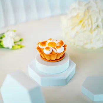 Tartaletka cytrynowa z bezą włoską w kształcie kwiatu, elegancko podana na białym tle